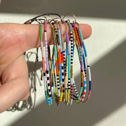 Rice beads stacked with small bracelets and jewelry.